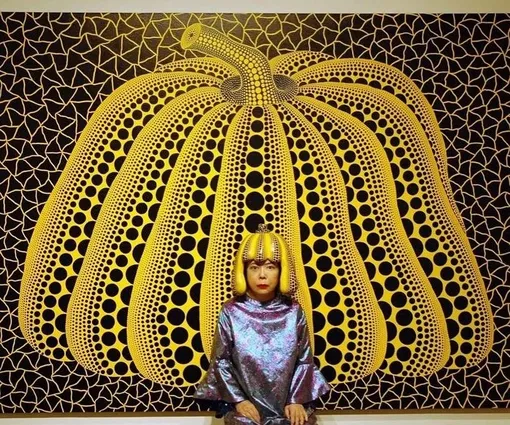 Яеи Кусама на фоне картины «Тыква», 2010 год